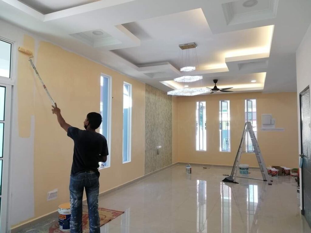 Worker painting an interior wall during a full house renovation in Taman Bukit Kinrara