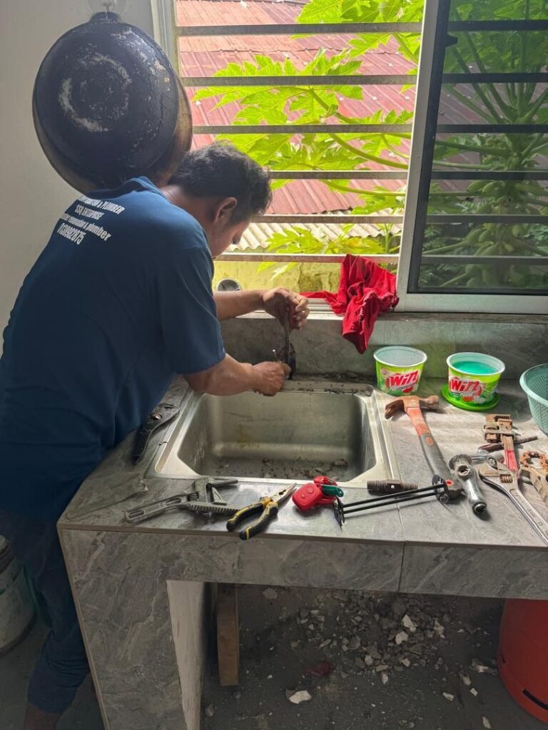 Plumber replacing a kitchen sink tap on a tiled counter in Bandar Sunway, Subang Jaya