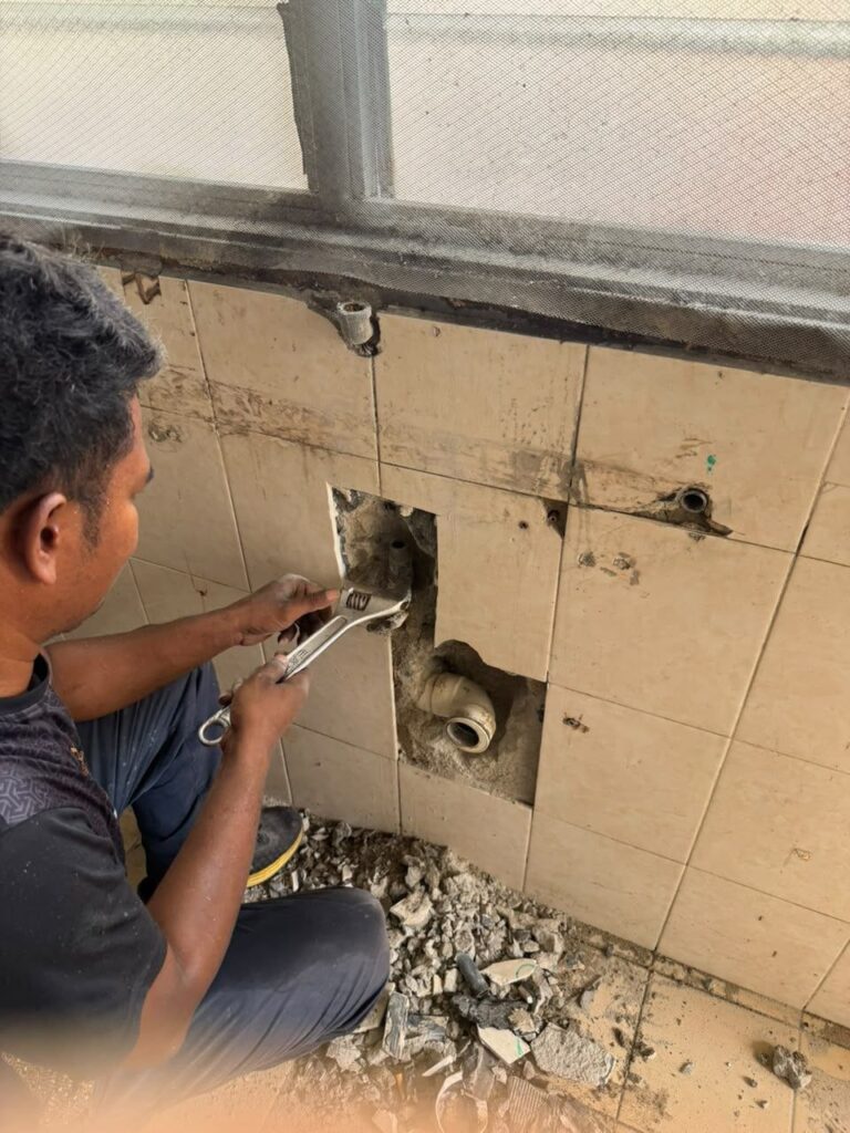 Plumber opening bathroom wall to repair hidden pipe leak in Putra Heights, Subang Jaya home
